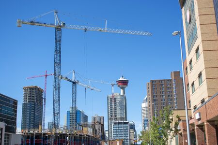 Modern building under construction in downtown with tower in background