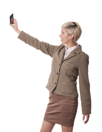 Happy young office worker takes a picture of herself with a cell phone の写真素材