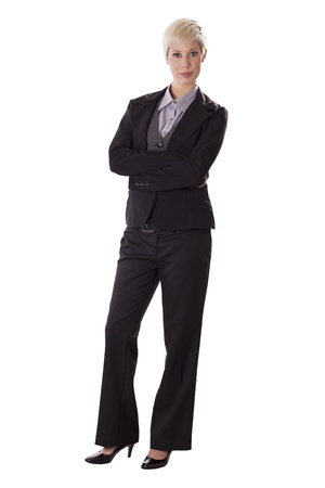 Female business professional in a pant suit stands with arms crossed の写真素材