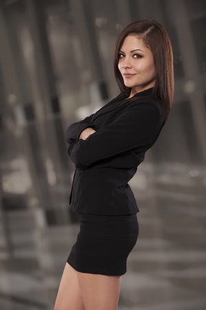 Beautiful business professional leans back smiling with arms crossed の写真素材