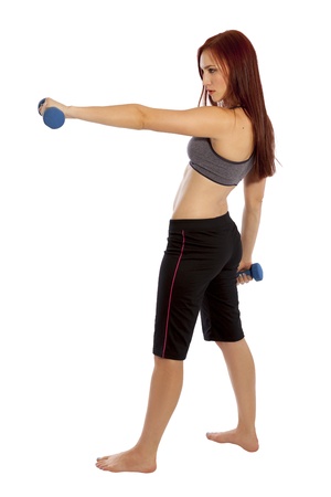 Pretty woman with red hair holds a hand weight out in front of herself の写真素材