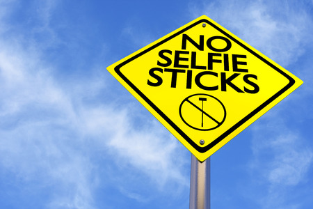 A yellow sign warns against taking selfies.の写真素材