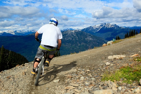 A biker is going to a downhill ride in the rocky mountains のeditorial素材