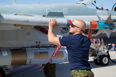 Bagotville, Canada- June 22, 2013: The Bagotville Airshow is a 2 days airshow where the Bagotville Airport opens to the public with a variety of aerial performers as well as aircraft and vehicles on display. This image shows a technician checking a missilのeditorial素材