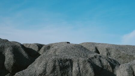 Crushed stone mountain against blue sky backgroundの写真素材