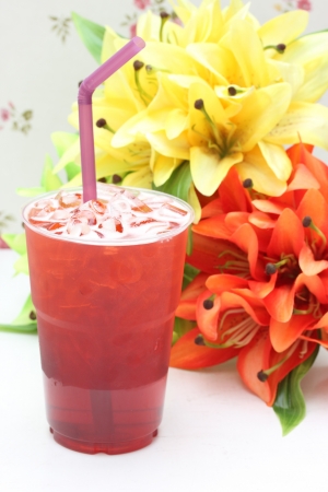 Glass of ice fruit tea with fabric flowersの写真素材