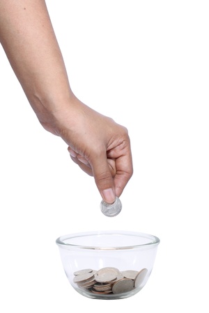 Save money, Woman hand drop the coin in glass bowl with coins isolated on white の写真素材