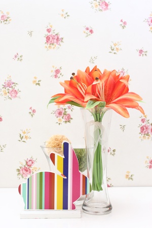 Fabric flower in glass vase with colorful wooden rabbitの写真素材
