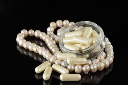 Pearl necklace and pearl capsule isolated on a black backgroundの写真素材