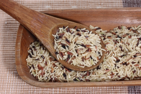 Mixed rice in wooden spoon and tray on cloth matの写真素材