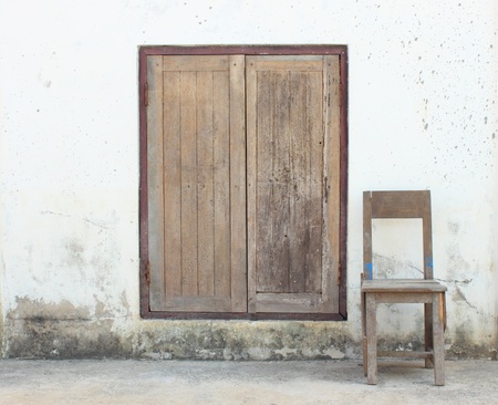 A chair outside of an old houseの写真素材