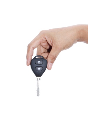 female hand holding remote control car key on white backgroundの写真素材