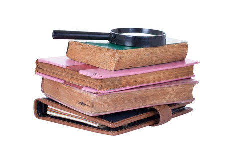 Magnifying glass and old book, isolated on whiteの写真素材