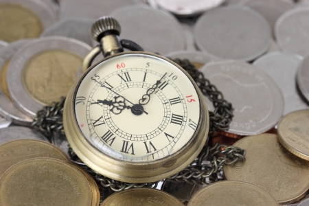 Financial concept, old watch with coinsの写真素材