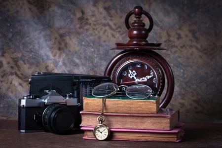Group of objects on wood table.  wood clock, old watch, retro radio, camera, Still lifeの写真素材