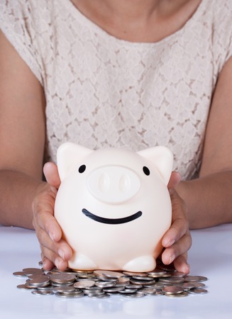 a piggy bank in the hands of a womanの写真素材