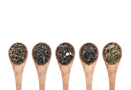 assortment of dry tea in wooden spoon, isolated on white backgroundの写真素材