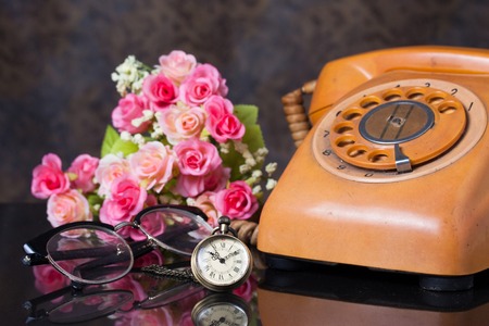 Group of objects on a granite,  old watch, old telephone, glasses, artificial flower, Still life