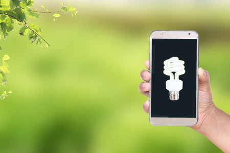 Women hand holding smart phone with light bulb