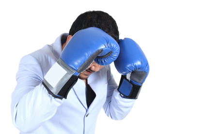 Businessman with boxing gloves guarding his faceの写真素材
