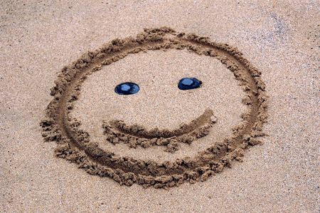a smile in the sand of the beachの写真素材