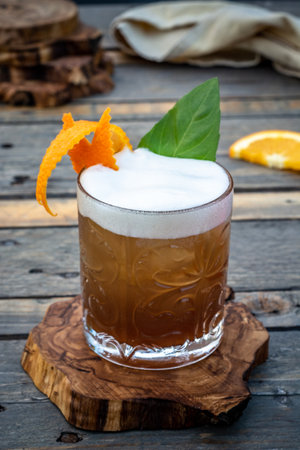 Summer Taste in a Glass: Cocktail on an Olive Tree Coaster - Relaxing Atmosphere on a Wooden Tableの写真素材