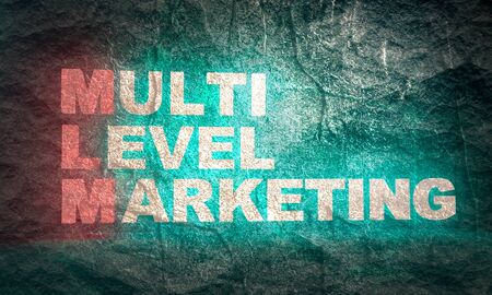 Acronym MLM - Multi level marketing. Business conceptual image. Neon bulb illuminationの写真素材