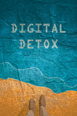 Digital detox concept illustration. Addiction of devices. Top view feet of businessman in black shoes at sea shore.の写真素材