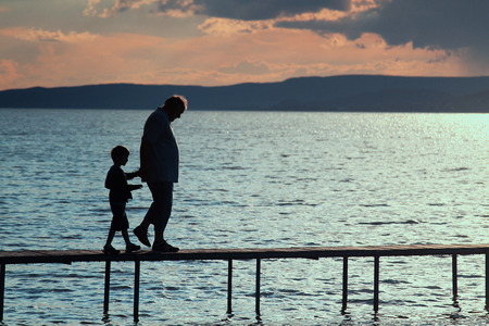 A man and a boy walking on the pierの写真素材