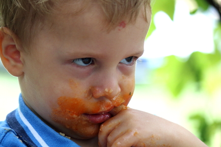 Little boy with clip left is eatingの写真素材