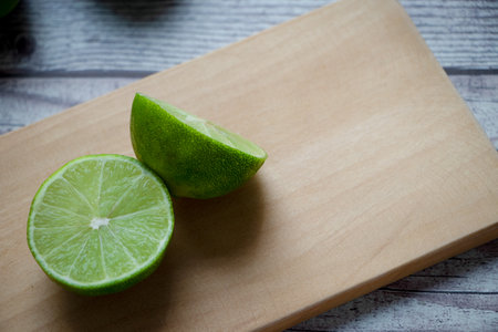 A lemon cut in half on a chopping board. Everything is on a rustic gray table.の写真素材