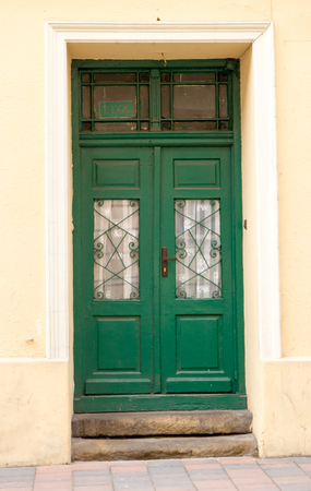 The vintage green design brown  wooden front door of an old houseの写真素材