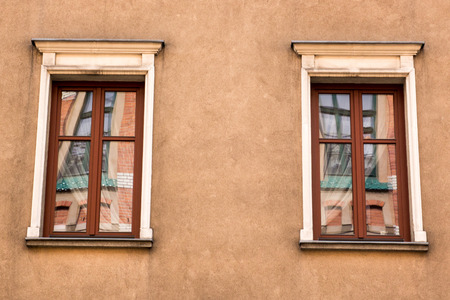 Two vintage design red windows on the facade of the old houseの写真素材
