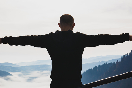 A young guy stands on top of a mountainの写真素材