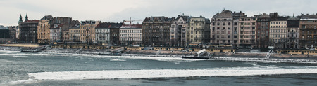 Panorama of the old vintage houses over the river Danube in Budapest on, the river floating ice