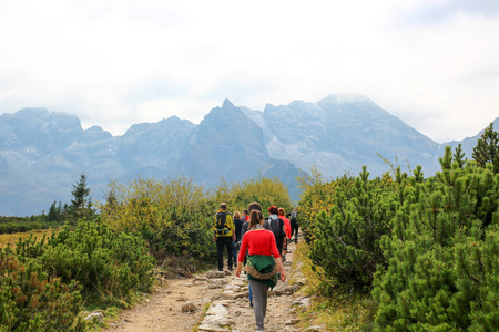 Group of people walking along a trail in the mountainsの写真素材