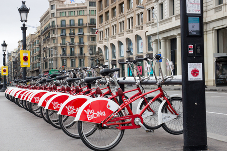 BARCELONA, SPAIN, February 4, 2018 Bicing bicycle rental station in Barcelona street, row of red and white bicycles in the background street and old vintage housesのeditorial素材