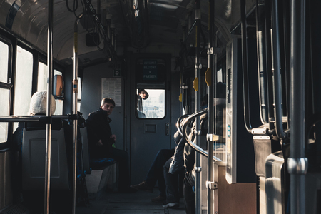 KRAKOW, POLAND, December 26, 2017 people are riding in a car of a dark half-empty city tramのeditorial素材