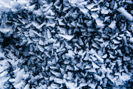 Frozen sharp little ice crystals close up, abstract blue winter backgroundの写真素材