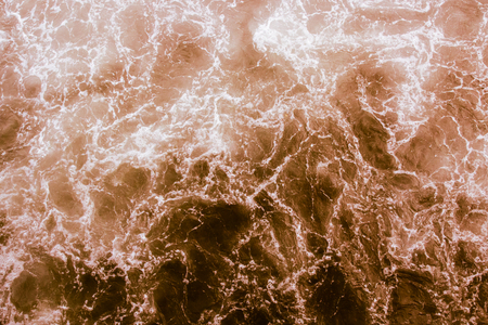 Bright brown water surface with waves and reflections, abstract background in retro styleの写真素材