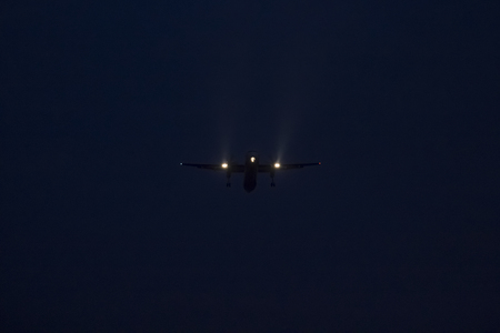 Passenger plane takes off at dusk against a dark blue night skyの写真素材
