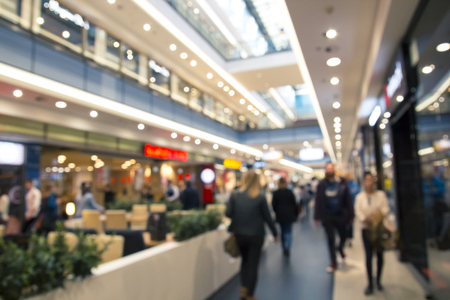 Many People and buyers walking inside a large shopping mall, a lot of shops and corridors, blurred conceptの写真素材