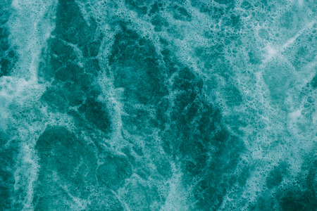 Bright abstract light turquoise background, water with white foam and bubblesの写真素材