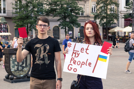Krakow, Poland, June 01, 2018, A young girl and a guy with a poster protesting against political prisoners in Russia, Let my people goのeditorial素材