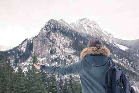 Young girl enjoying beautiful winter mountain landscapeの写真素材