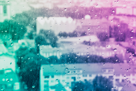 Raindrops on the  glass, behind the glass blurred panorama of the old bright colored city, Neon Inspiration surreal abstract background wallpaperの写真素材