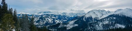 Panorama of snow-capped mountains, snow and clouds on the horizonの写真素材
