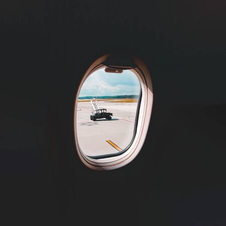 View through the window of the airport and transport from inside the passenger planeの写真素材