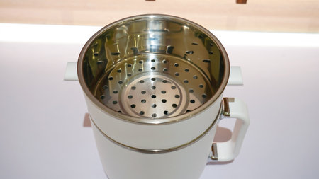 A white electric steamer is a kitchen appliance used for steaming food. It has multiple layers or compartments where food can be placed and cooked simultaneously using steam.の写真素材