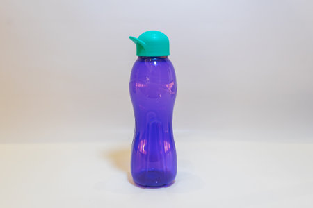 The Purple Water Bottle with Teal Green Lid is the perfect companion to keep you hydrated throughout the day.の写真素材